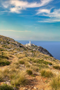 Lighthouse by sea against sky