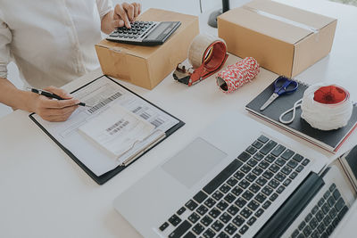 Midsection of woman using laptop on table