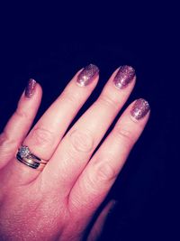 Close-up of woman hand against black background