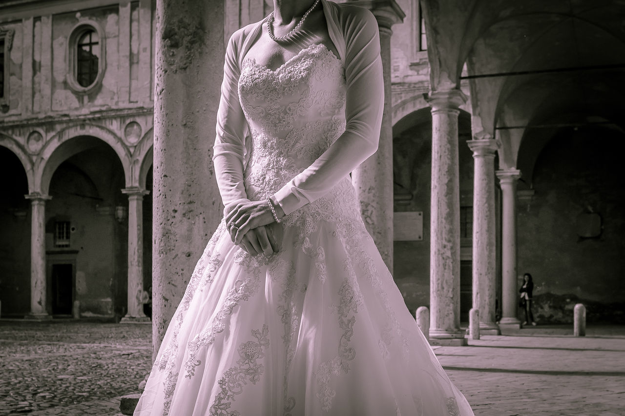 wedding dress, celebration, wedding, bride, women, event, architecture, dress, adult, clothing, bridal clothing, newlywed, black and white, fashion, gown, female, life events, built structure, white, one person, arch, religion, place of worship, standing, building exterior, building, monochrome, love, young adult, emotion, person, architectural column, formal wear, monochrome photography, elegance, veil