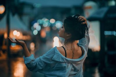 Side view of young woman standing outdoors