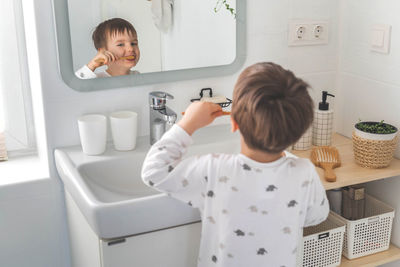 Side view of mother and daughter in bathroom