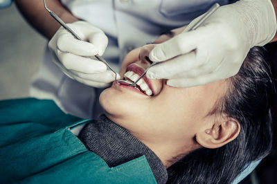 Midsection of dentist examining female patient