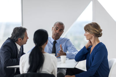 Businessman and businesswomen talking while drinking coffee