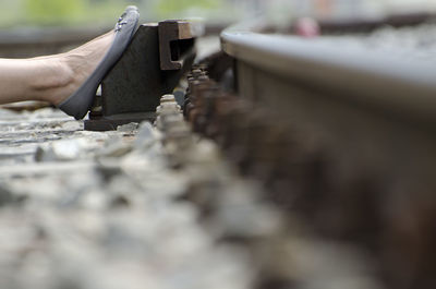 Close-up of leg on railroad track