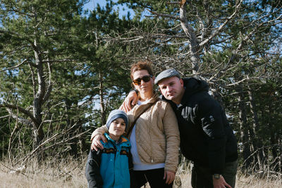 Portrait of family standing against trees at forest