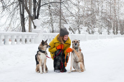 Woman with dogs on snow covered street