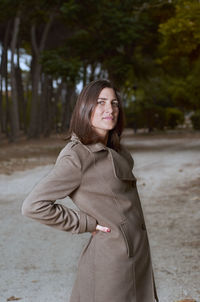 Portrait of woman wearing coat standing on road