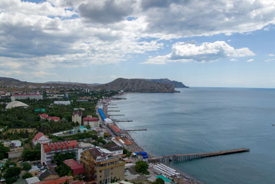 High angle view of townscape by sea against sky