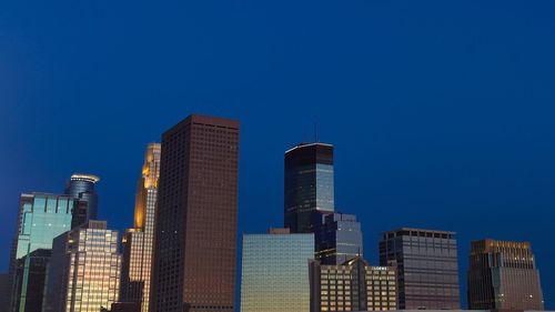 Low angle view of buildings against clear blue sky