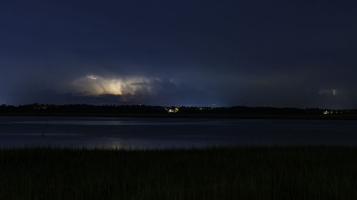 Scenic view of lake against sky at night