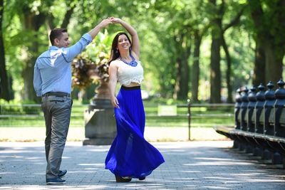 Happy friends dancing in park