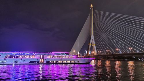 View of illuminated boat in river at night