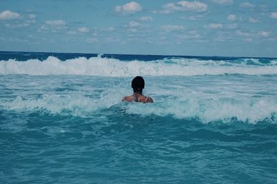 Man in sea against sky