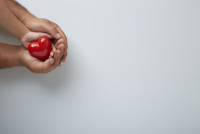 Midsection of woman holding hands over white background