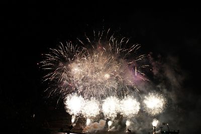 Low angle view of firework display at night