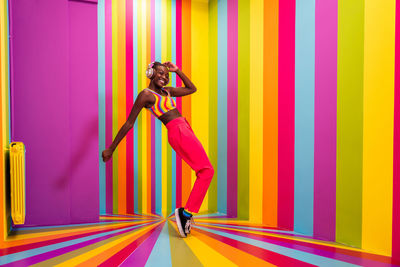 Full length of woman wearing costume against multi colored background