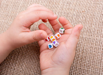 Close-up of hands holding colorful dices at table