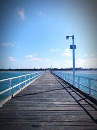 Pier over sea against blue sky