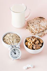 Good sleep. foods for good sleep - milk, walnuts, crispbread, oatmeal and alarm clock on pink 