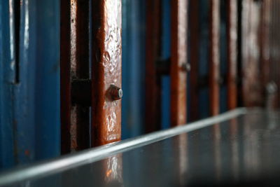 Close-up of rusty metal fence against building