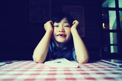 Portrait of cute boy sitting at home