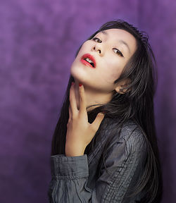 Portrait of woman against purple wall