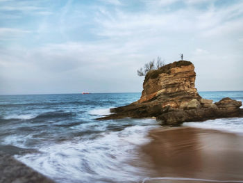 Scenic view of rocks on sea against sky