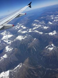 Aerial view of aircraft wing over landscape against sky