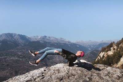 Man levitating over mountain against clear sky