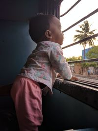 Cute baby girl looking through train window