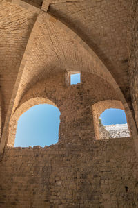 Low angle view of arched wall against sky
