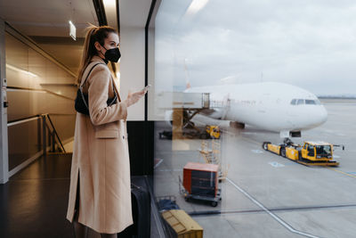 Side view of young woman standing at airport