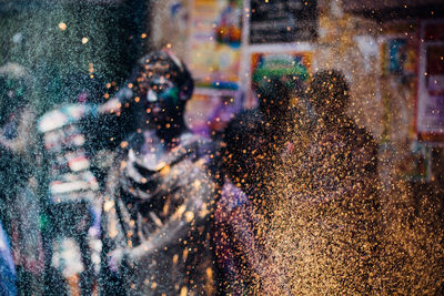 Close-up of yellow and green powder paint with people playing in background