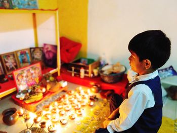 Side view of boy praying while at home