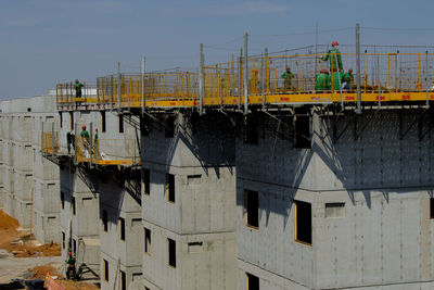 Construction site by buildings against sky in city