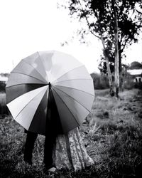 Close-up of umbrella on field against sky