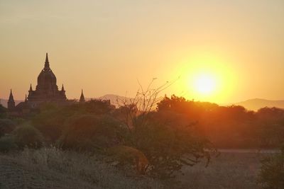 Panoramic view of trees and buildings against sky during sunset