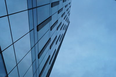 Low angle view of skyscrapers against blue sky