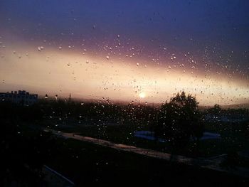 View of sunset through wet window