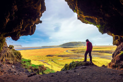 Rear view of man standing on land against sky