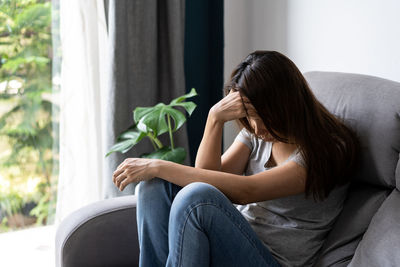 Woman sitting on sofa at home