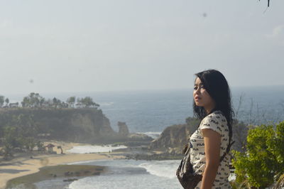 Side view of young woman looking at sea