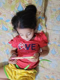 High angle view of cute girl relaxing on bed at home