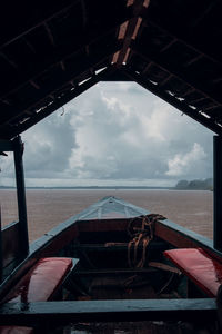 Old boat in river against sky