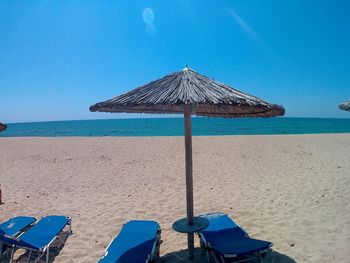 Parasols over lounge chairs on shore at beach