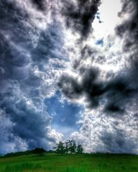 Low angle view of storm clouds over field