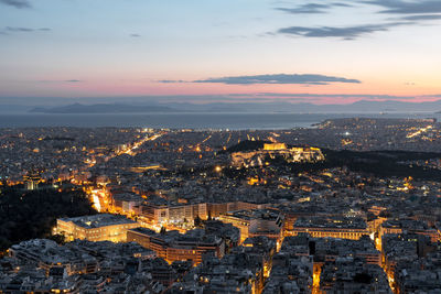 Aerial view of city lit up at sunset