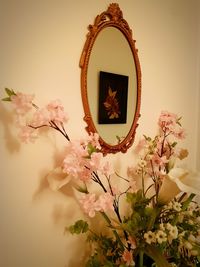 Close-up of white flowering plant in vase against wall