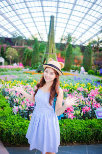 Portrait of smiling young woman standing against eiffel tower replica